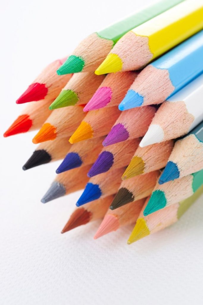 sharpened colored pencils in stack on white background