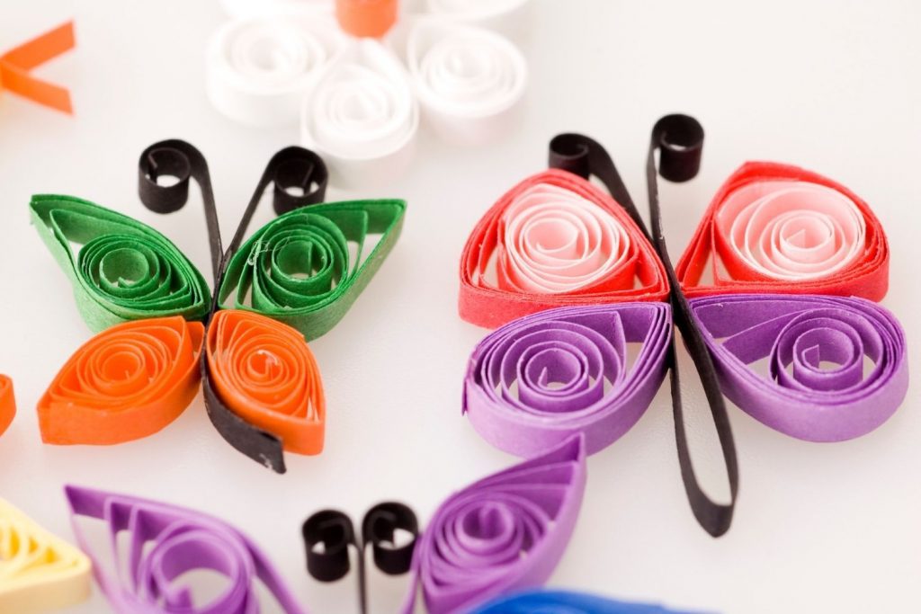 Colored paper rolls into quilling butterfly project