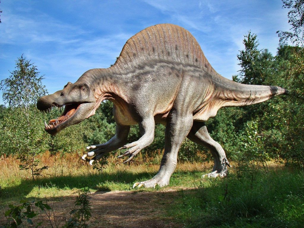 Fake dinosaur statue in field outdoors