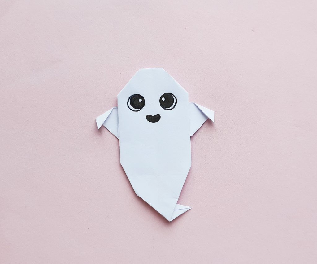 origami paper ghost on pink background